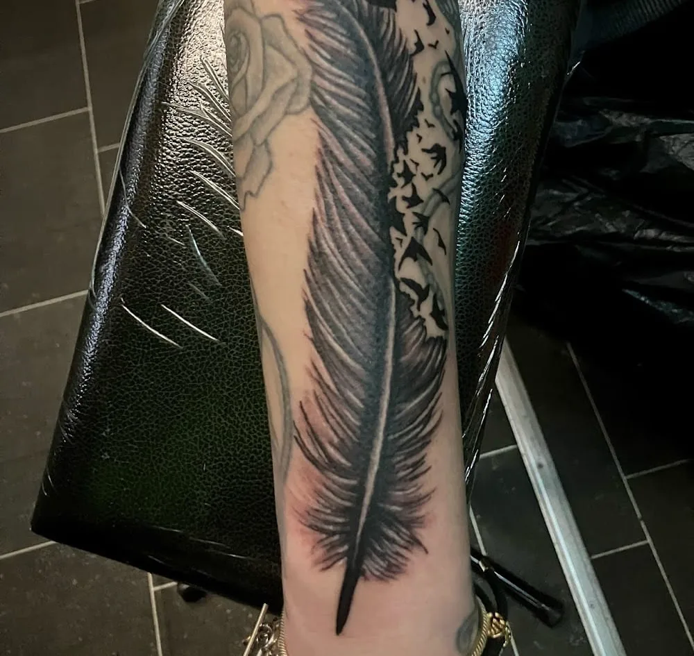 Black and grey feather with birds and rose forearm tattoo, N9 Tattoo Studio, Edmonton Green